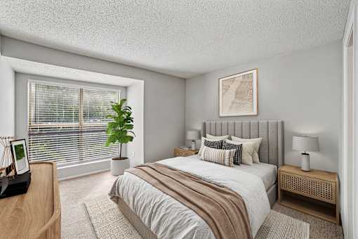 A bedroom with a large bed and a window with blinds at Beacon Ridge Apartments, PRG Real Estate Management, Greenville, 29615