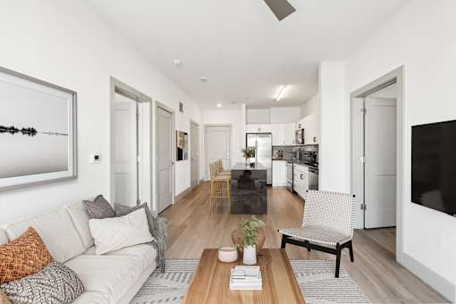 A modern living room with a white couch and a wooden coffee table at The Point Apartments on 38th, Norfolk, Virginia
