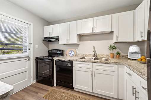 A kitchen with white cabinets and a black oven at Rivers Landing Apartments, Hampton 23666