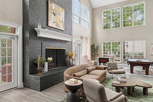 A living room with a fireplace and a pool table.