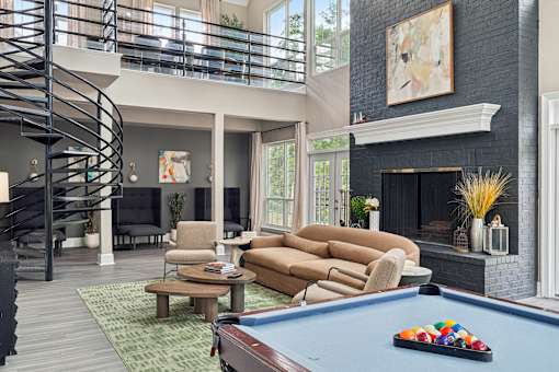 A living room with a pool table and a fireplace.