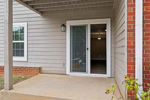 A white door with a glass window is on the side of a house.