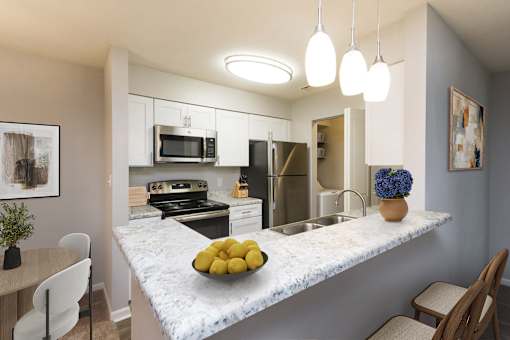 A kitchen with a marble countertop and a bowl of lemons on it.