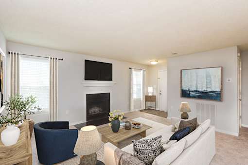 A living room with a fireplace and a painting on the wall.