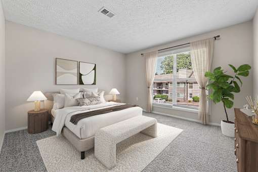 Primary bedroom with large windows, plush carpeting and abundant natural light