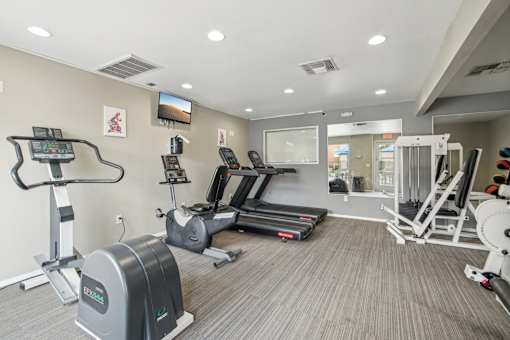 A gym with treadmills, elliptical machines, and other exercise equipment.