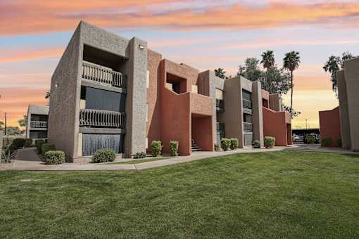 A modern building with a green lawn in front.