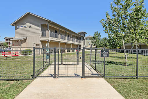 A gated entrance to a building with a sign on the fence.
