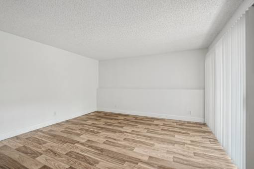 A room with wooden flooring and white walls.