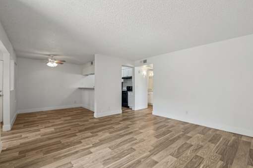 A room with wooden flooring and white walls.