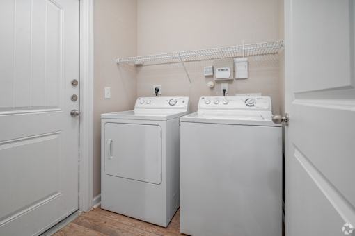 A small laundry room with a washer and dryer at Overlook at Stone Oak Park Apartments, San Antonio