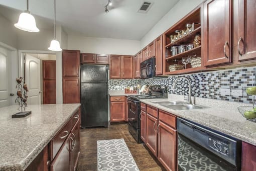 Kitchen with Wood Cabinets & Granite Countertops at Overlook at Stone Oak Park Apartments, San Antonio, Texas