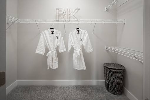 two white robes hanging in a walk-in closet
