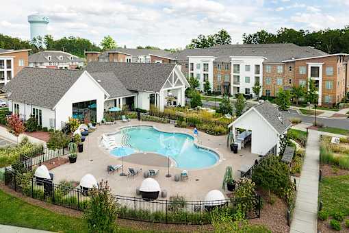 an aerial view of an outdoor pool with apartments in the background