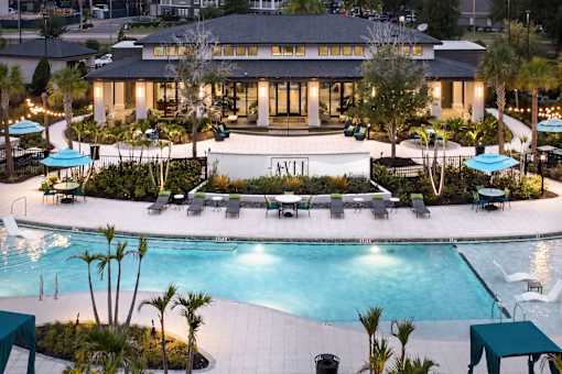 Clubhouse and swimming pool at twilight at Avli At Crosstown Center Apartments, TAMPA, FL