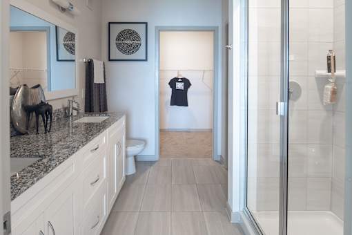 Spacious bathroom with dual vanity and glass shower at Avli At Crosstown Center Apartments, TAMPA, Florida