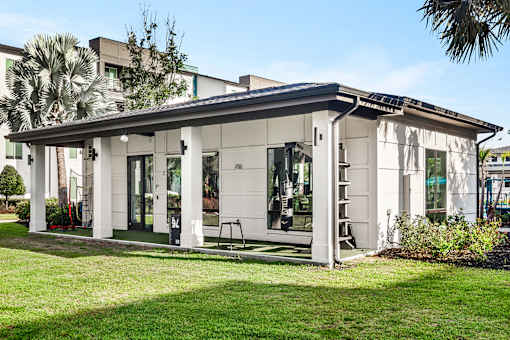 Outdoor clubhouse with covered porch and open lawn at Avli At Crosstown Center Apartments, TAMPA, Florida