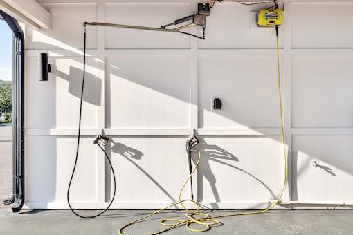 Garage workspace with retractable hose reels at Avli At Crosstown Center Apartments, TAMPA, FL