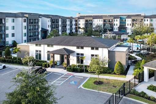 Clubhouse entrance with accessible parking and landscaping at Avli At Crosstown Center Apartments, Florida