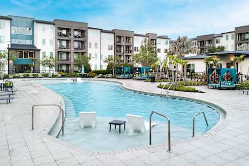 Resort style pool with cabanas and tropical landscaping at Avli At Crosstown Center Apartments, TAMPA, FL 33619