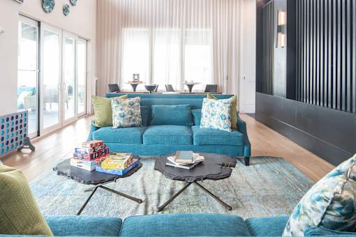 Open concept living and dining room with blue sofa at Avli At Crosstown Center Apartments, TAMPA, FL