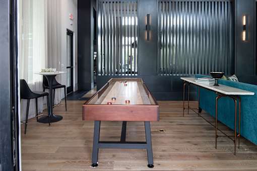 Game room with shuffleboard table and lounge seating at Avli At Crosstown Center Apartments, TAMPA, 33619