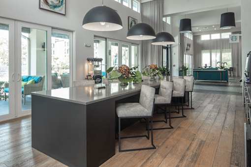 Clubhouse cafe with espresso machine and pendant lighting at Avli At Crosstown Center Apartments, Florida