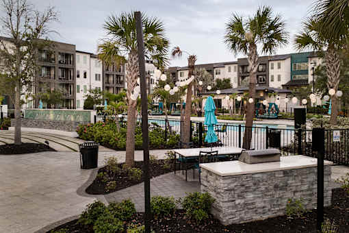 Outdoor patio with string lights and swimming pool at Avli At Crosstown Center Apartments, TAMPA, FL 33619