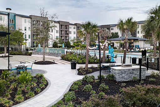 Courtyard walkway with palm trees and pool area at Avli At Crosstown Center Apartments, Florida