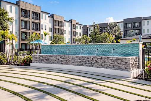 Water feature wall with stone base and landscaping at Avli At Crosstown Center Apartments, Florida, 33619