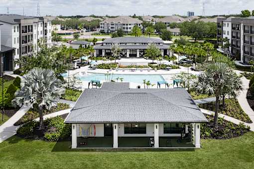 Outdoor pavilion with pool and clubhouse views at Avli At Crosstown Center Apartments, TAMPA, Florida