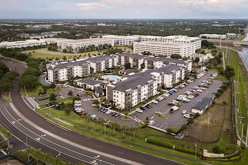 Aerial view of apartment community with parking and office buildings at Avli At Crosstown Center Apartments, Florida, 33619