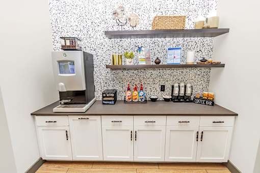 a coffee bar with a coffee machine and a coffeemaker on a counter