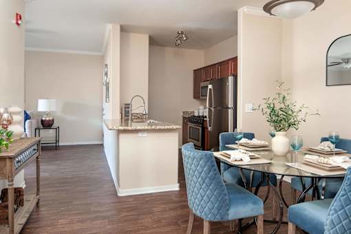 a dining room and kitchen with a table and chairs