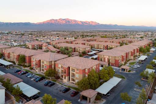 A large apartment complex with a mountain in the background.