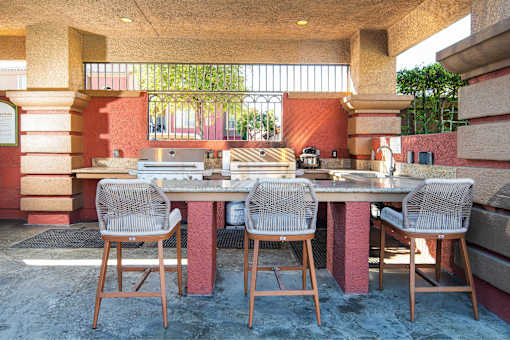 A table with four chairs is in front of a red wall.