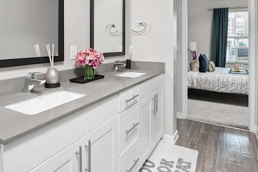 Bathroom with vanity and two sinks at Pointe at Lake Crabtree Apartments, Morrisville