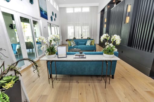 a living room with a blue couch and white flowers on the table