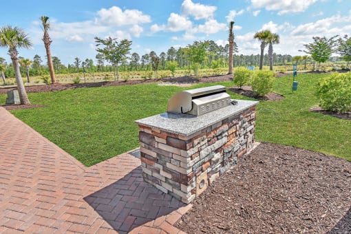 a backyard with a bbq and a grassy area