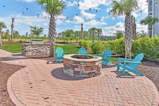 an outdoor patio with a fire pit and chairs