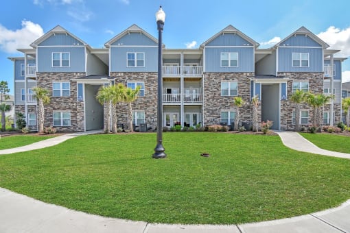 an image of an apartment building with a green lawn