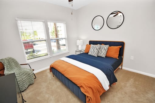a bedroom with a bed and two windows