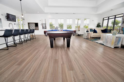 a pool table in a living room with hardwood floors
