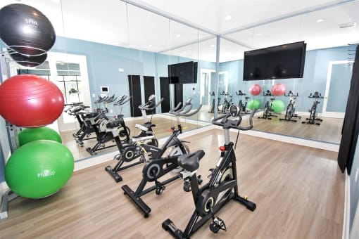 a room filled with lots of exercise equipment and a large window