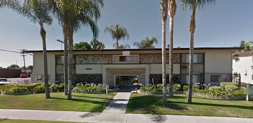 A building with palm trees in front of it.