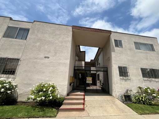 A white building with a red staircase leading to the entrance.