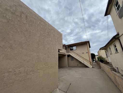 A concrete wall with a building in the background.