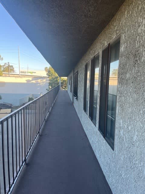 A balcony with a metal railing and a concrete wall.