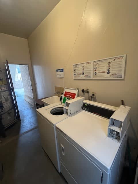 A white washing machine with a dryer on top of it.