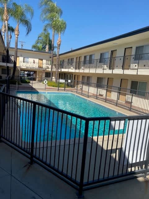 A pool surrounded by a black fence.